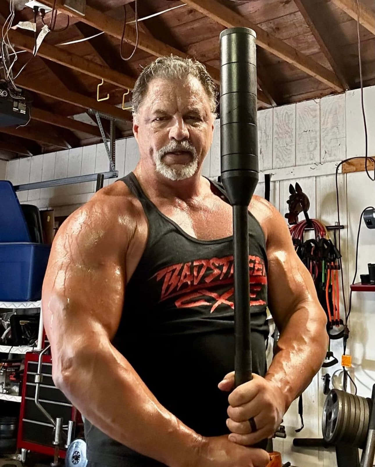 Muscled Manin Gym Holding Weighted Bar Background