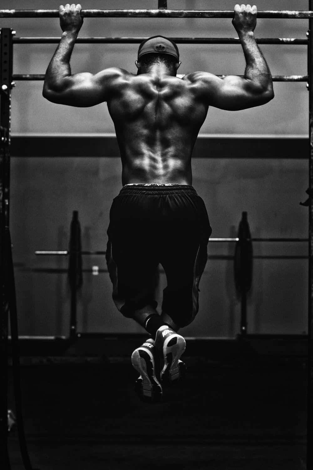 Muscular Man Performing Pull Up Workout Background