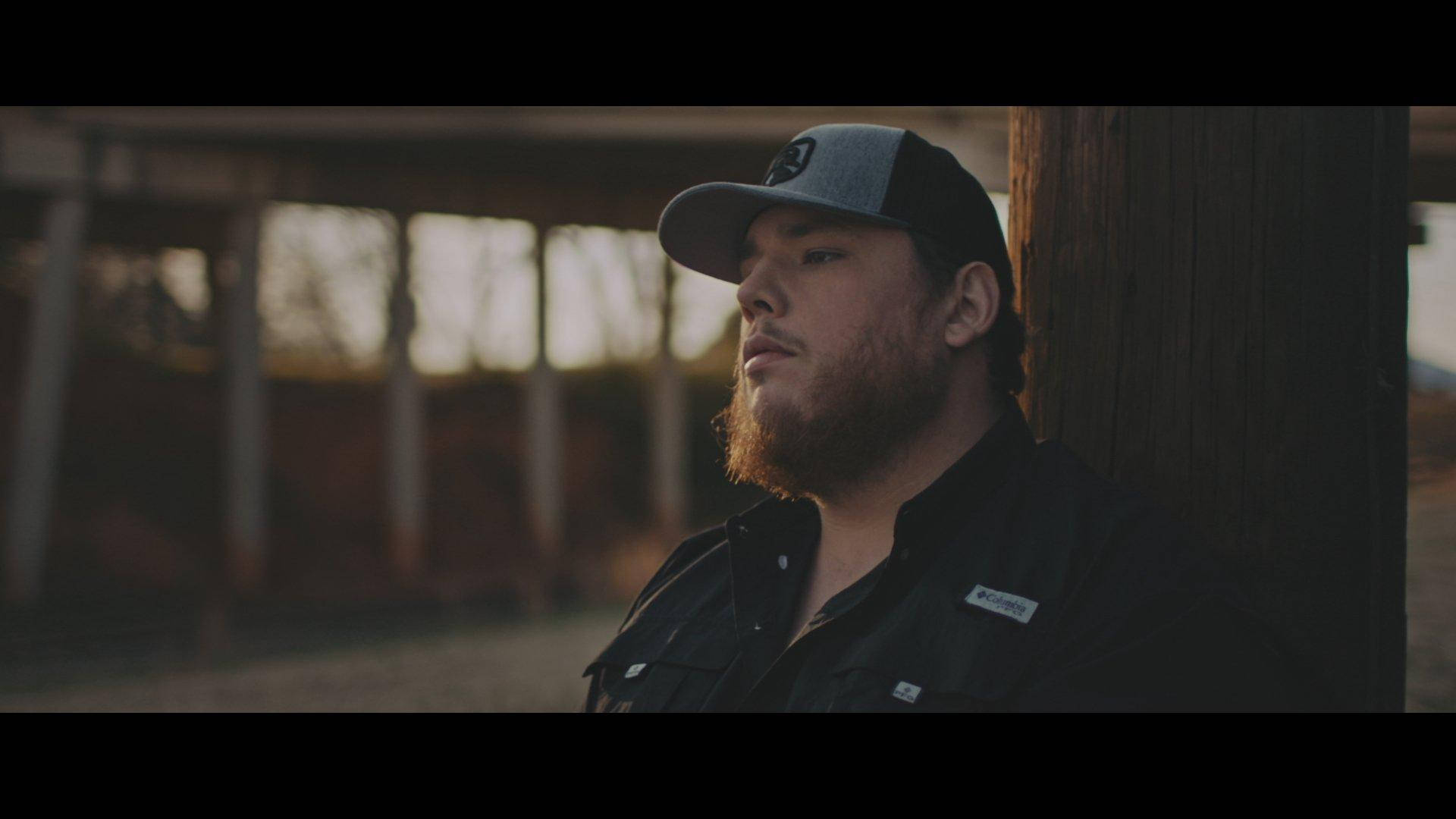 Musician Luke Combs Performing On Stage With A Classic America Flag Background Background