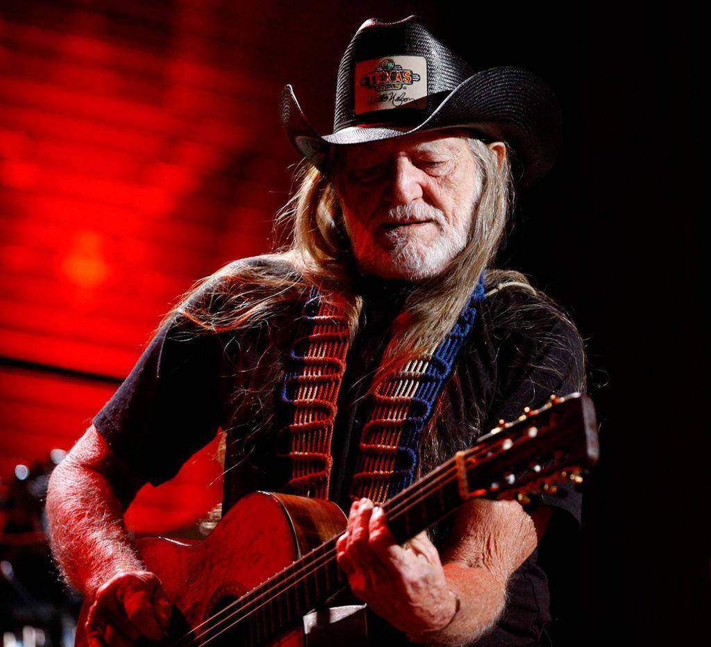 Musician Willie Nelson Playing Guitar Background