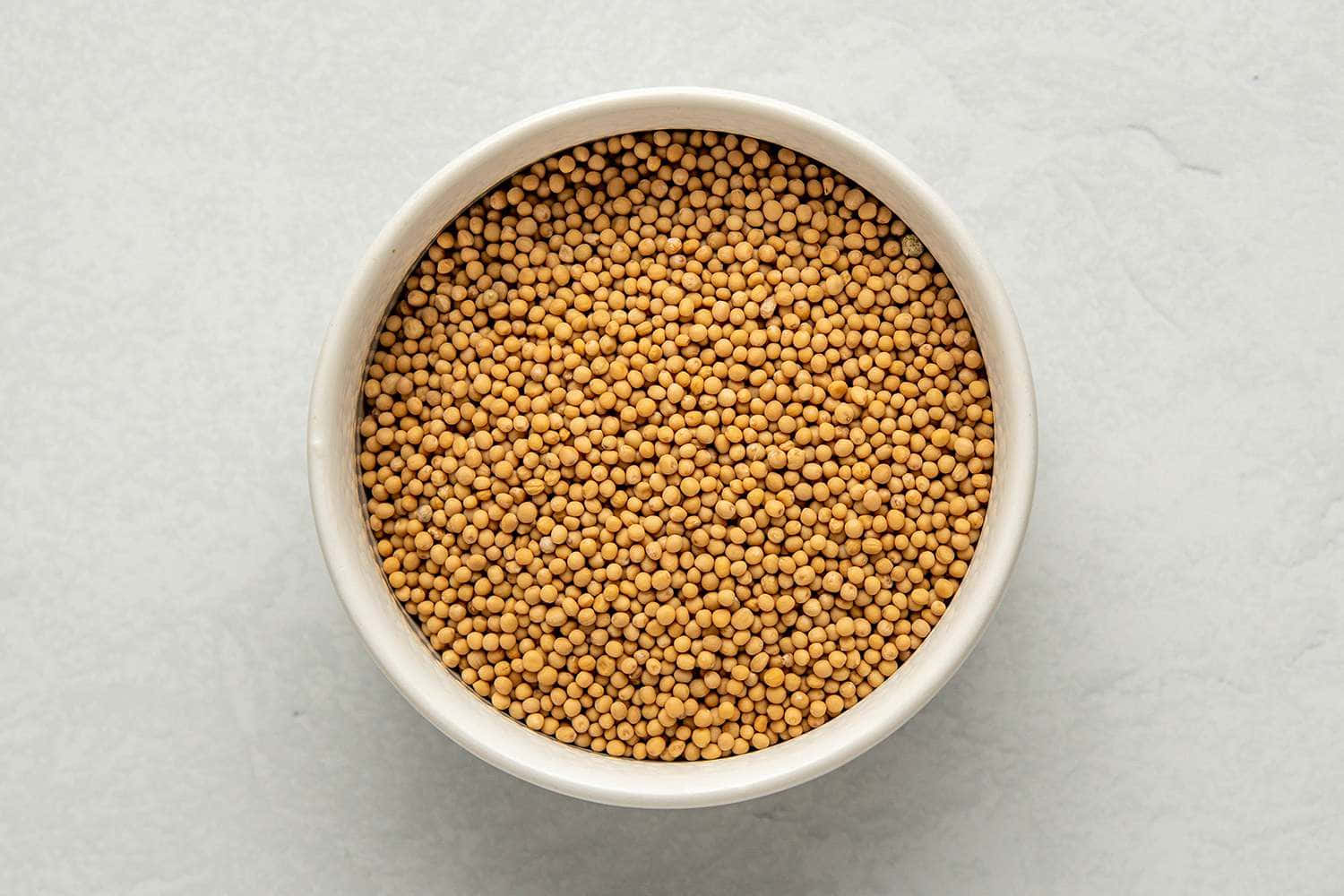 Mustard Seedsin White Bowl Background