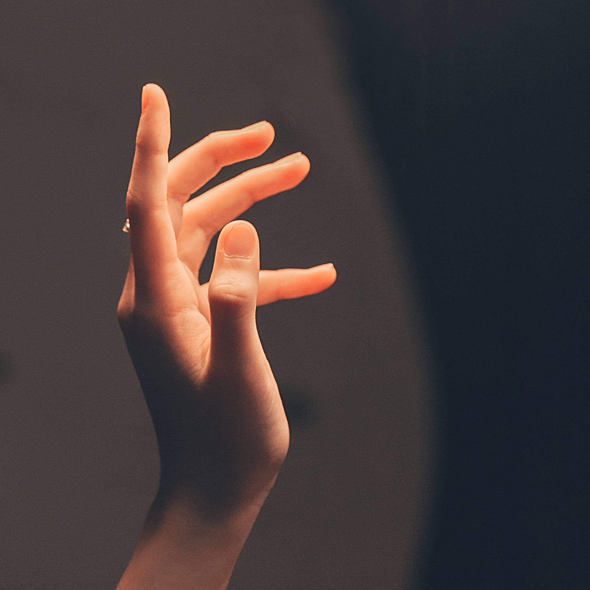 Mysterious Glowing Hand Illuminating The Darkness Background