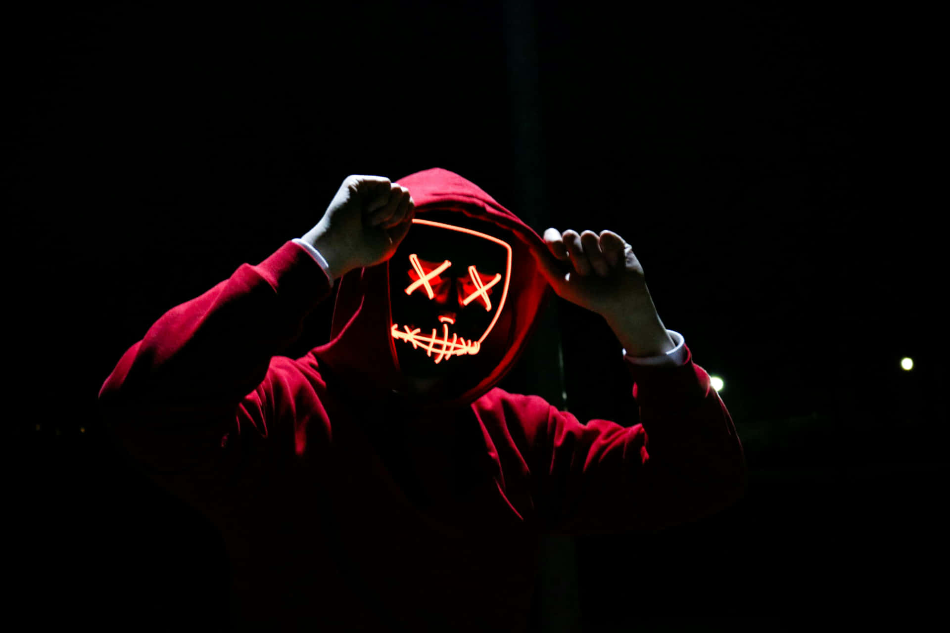 Mysterious Hooded Figurewith Neon Mask4k.jpg Background