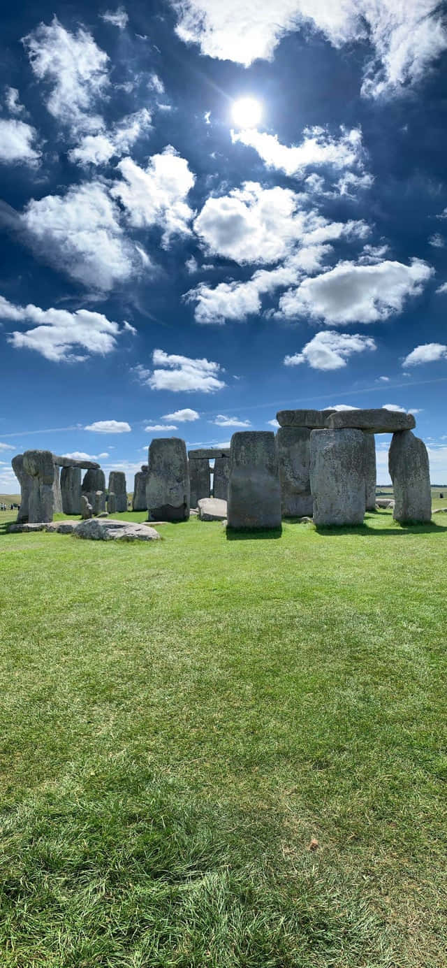 Mystical Stonehenge Amidst The Verdant Plains Background