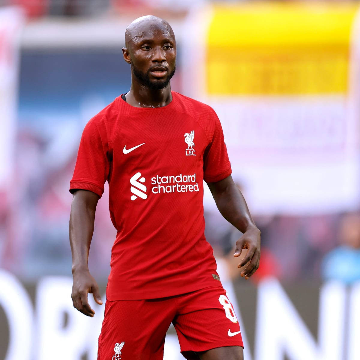 Naby Keita In Action: Dressed In Bright Reds Background