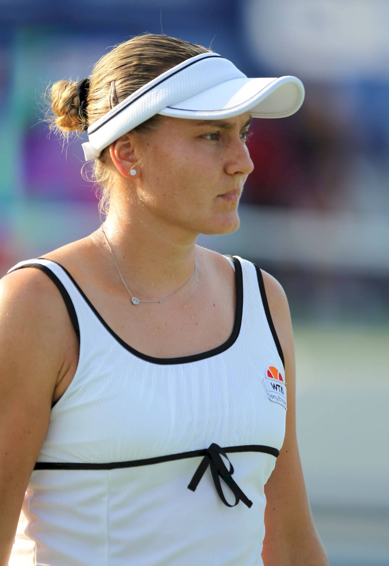 Nadia Petrova Gracefully Poses In A White Visor And Dress Background