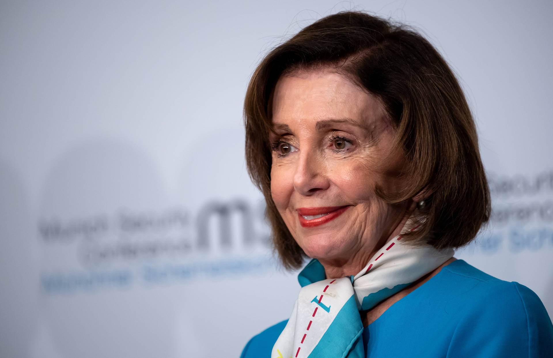 Nancy Pelosi In Blue Attire Wearing A Scarf