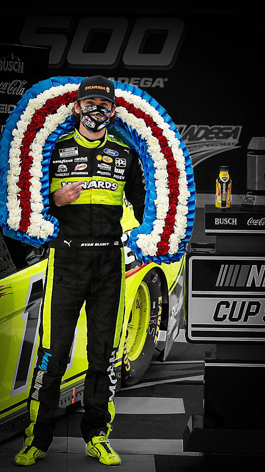 Nascar Driver Ryan Blaney Posing With Red And White Flowers Background