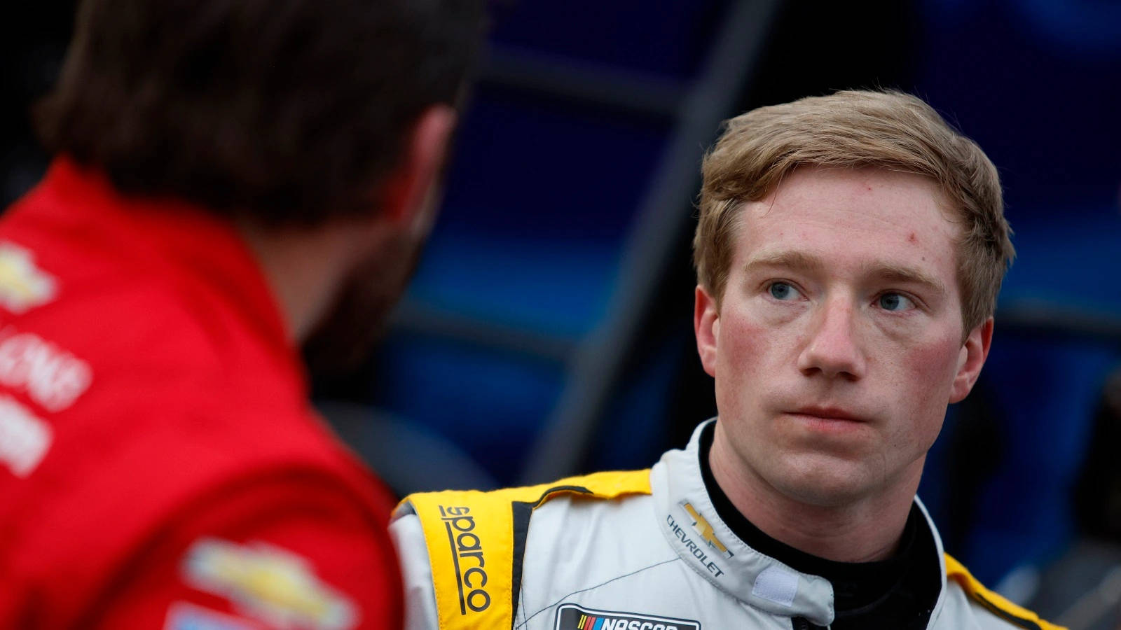 Nascar Driver Tyler Reddick Observing Competition During A Race Background