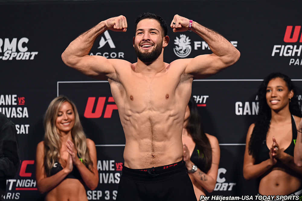 Nassourdine Imavov Celebrating Victory With Ring Girls Background