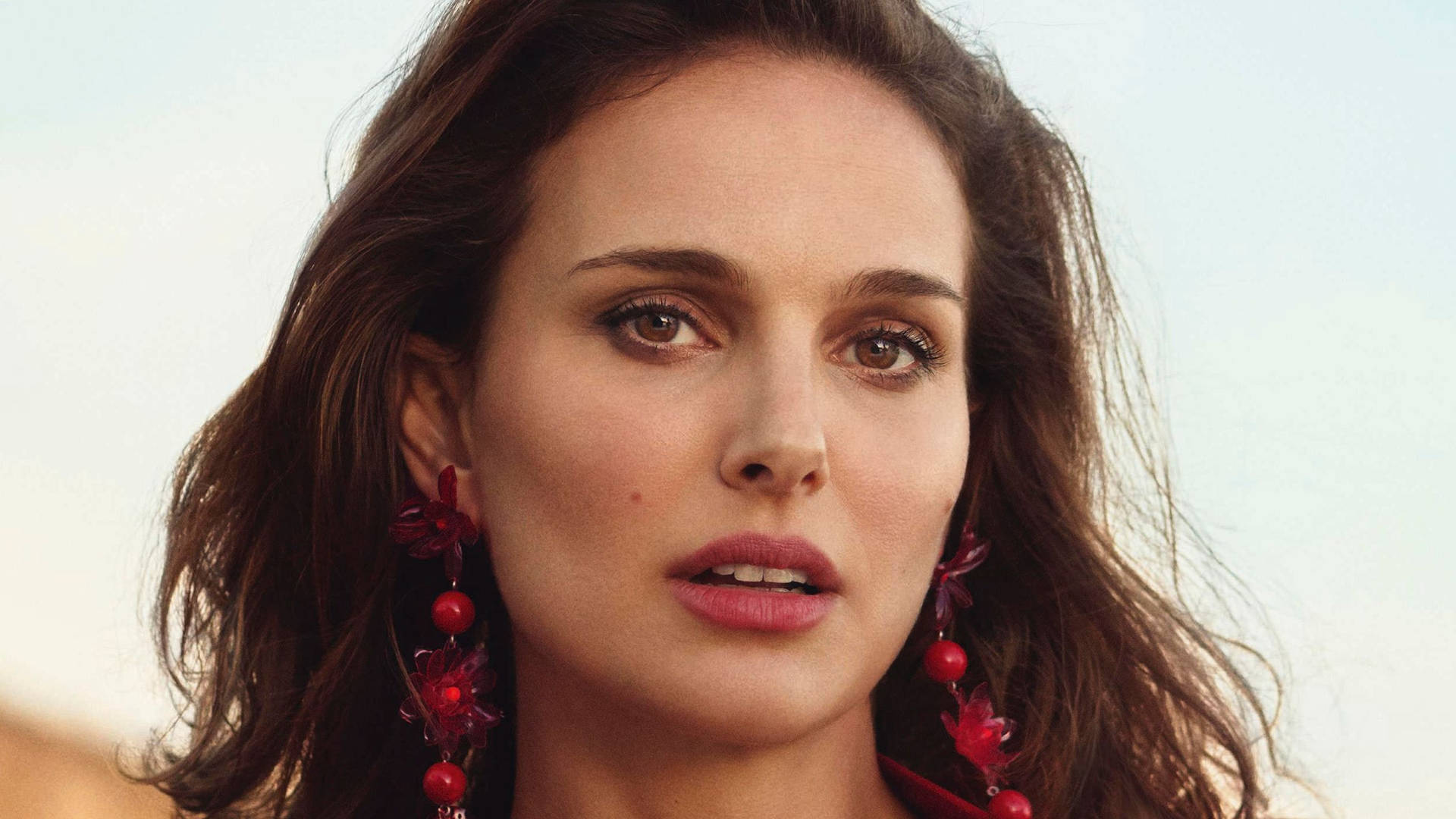 Natalie Portman Exemplifying Elegance With Red Earrings Background