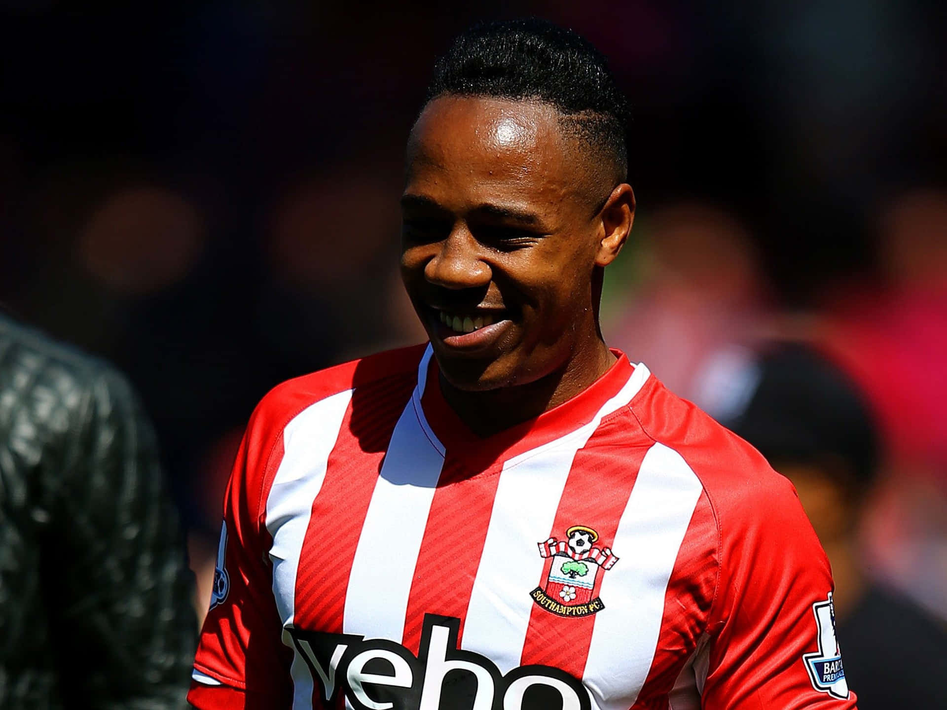 Nathaniel Clyne Smiling Brightly On The Field Background