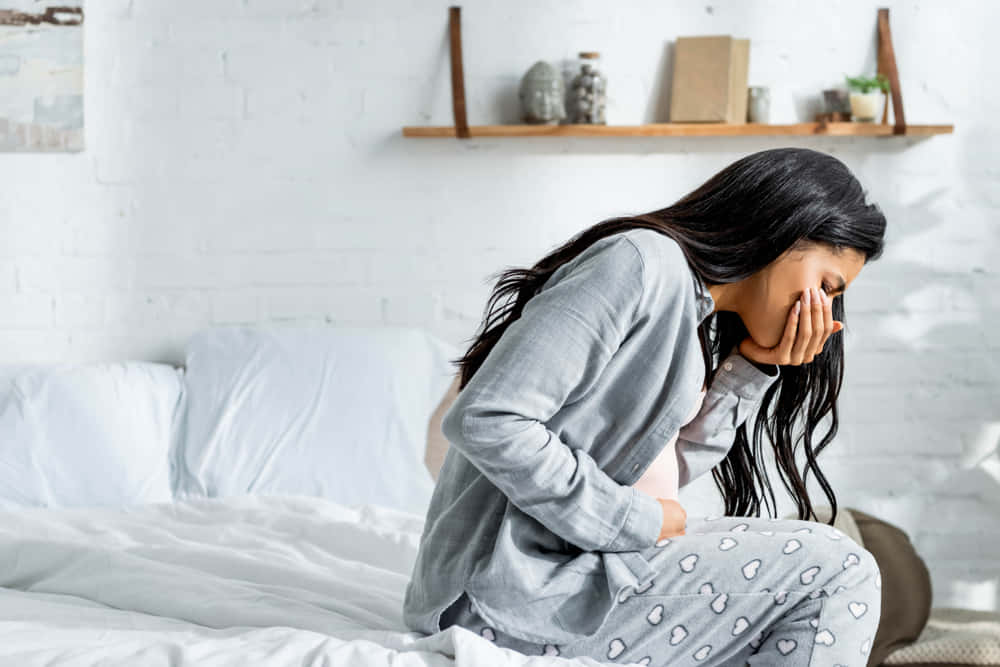 Nauseous Pregnant Woman On Bed