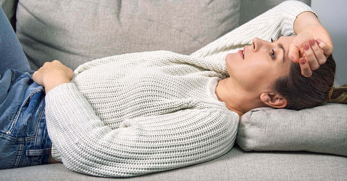 Nauseous Woman Lying With Hands On Head Background