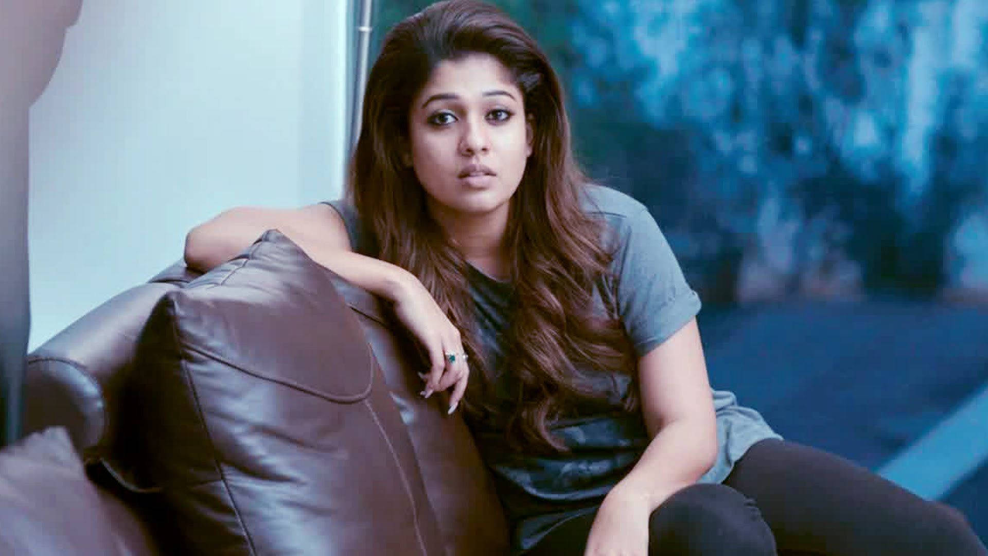 Nayanthara Lounging In Style On A Rich Brown Couch. Background