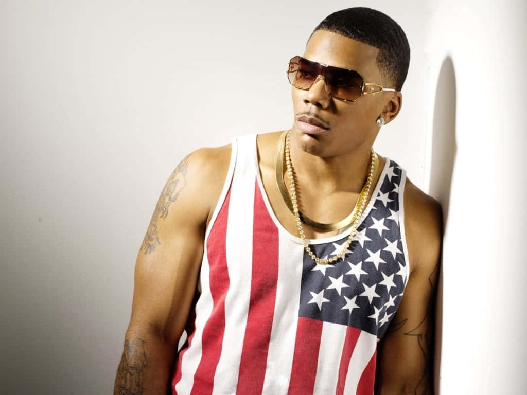 Nelly Leaning On Wall With Fierce Expression Background