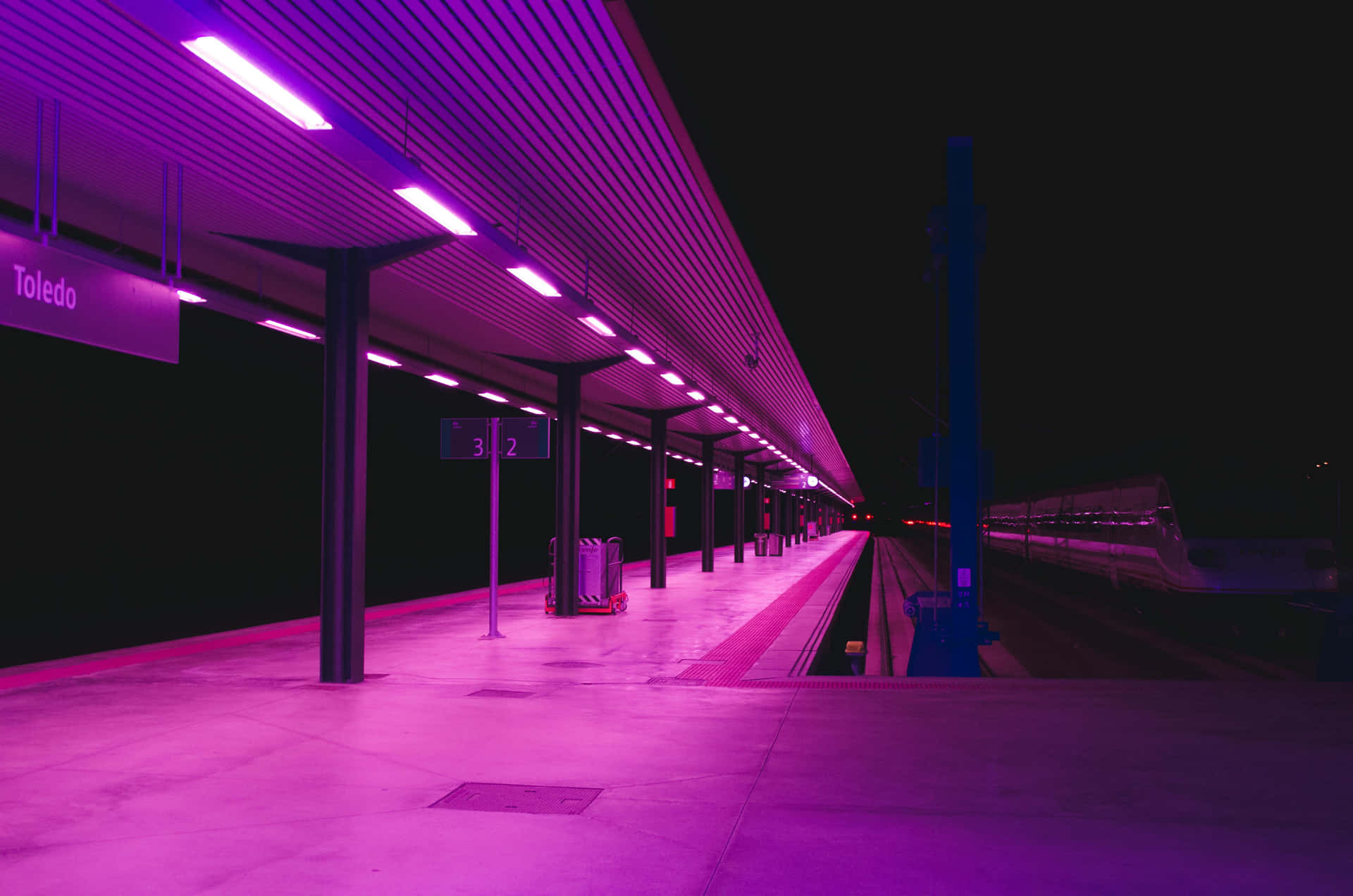 Neon Lit Train Stationat Night Background