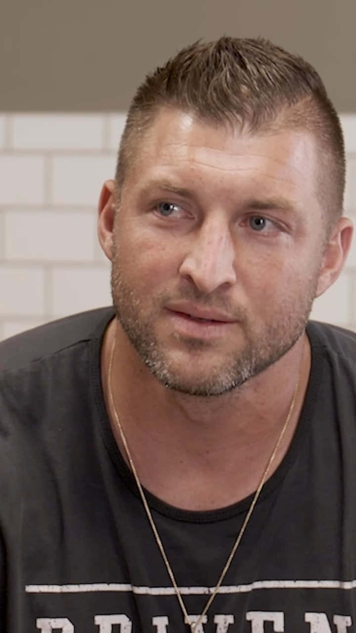 Nfl Quarterback Tim Tebow On The Field Background