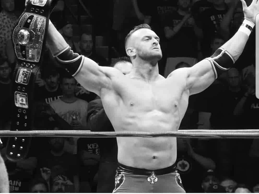 Nick Aldis Victory Posewith Championship Belt Background