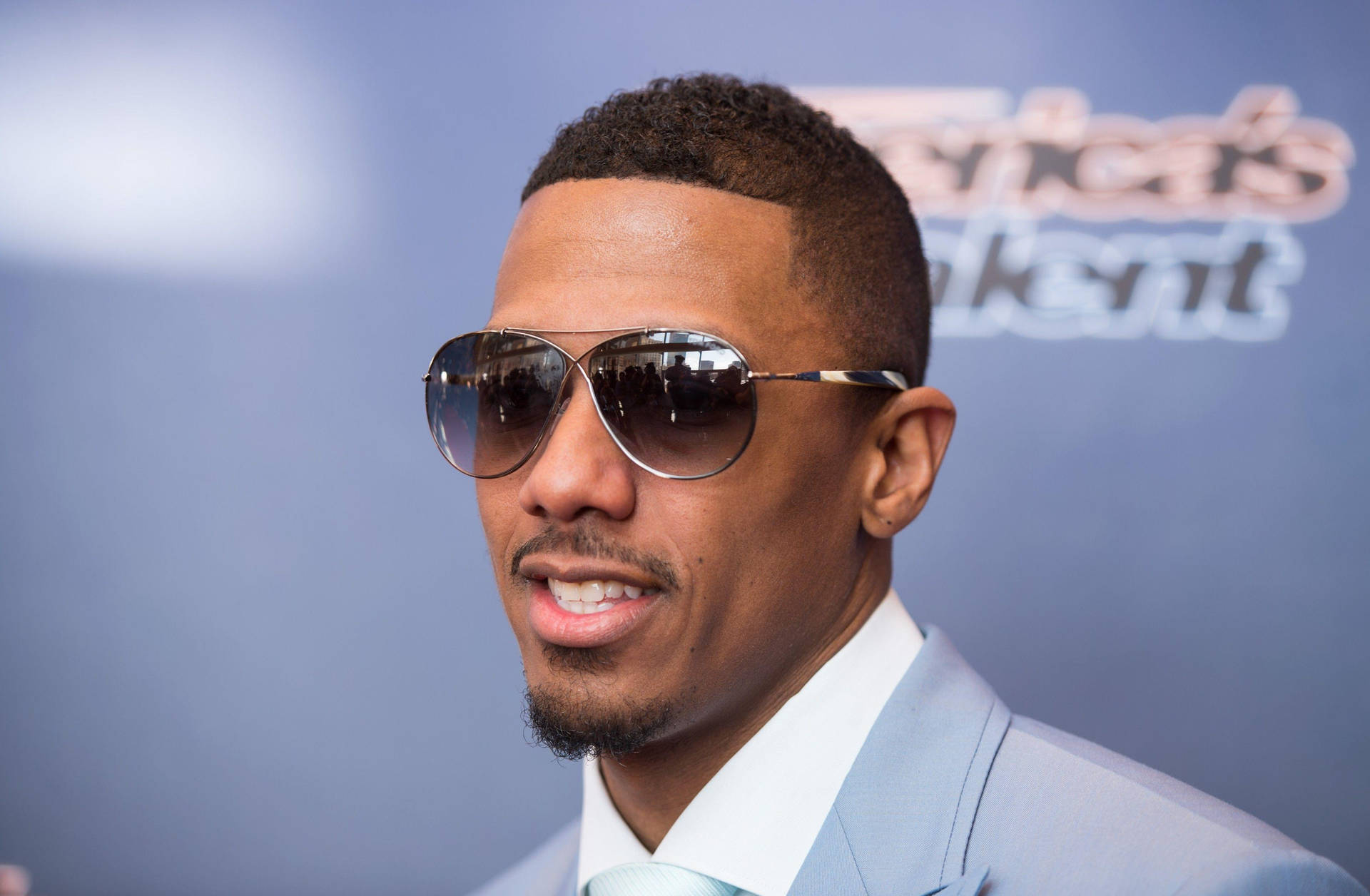 Nick Cannon Posing With Shades Background