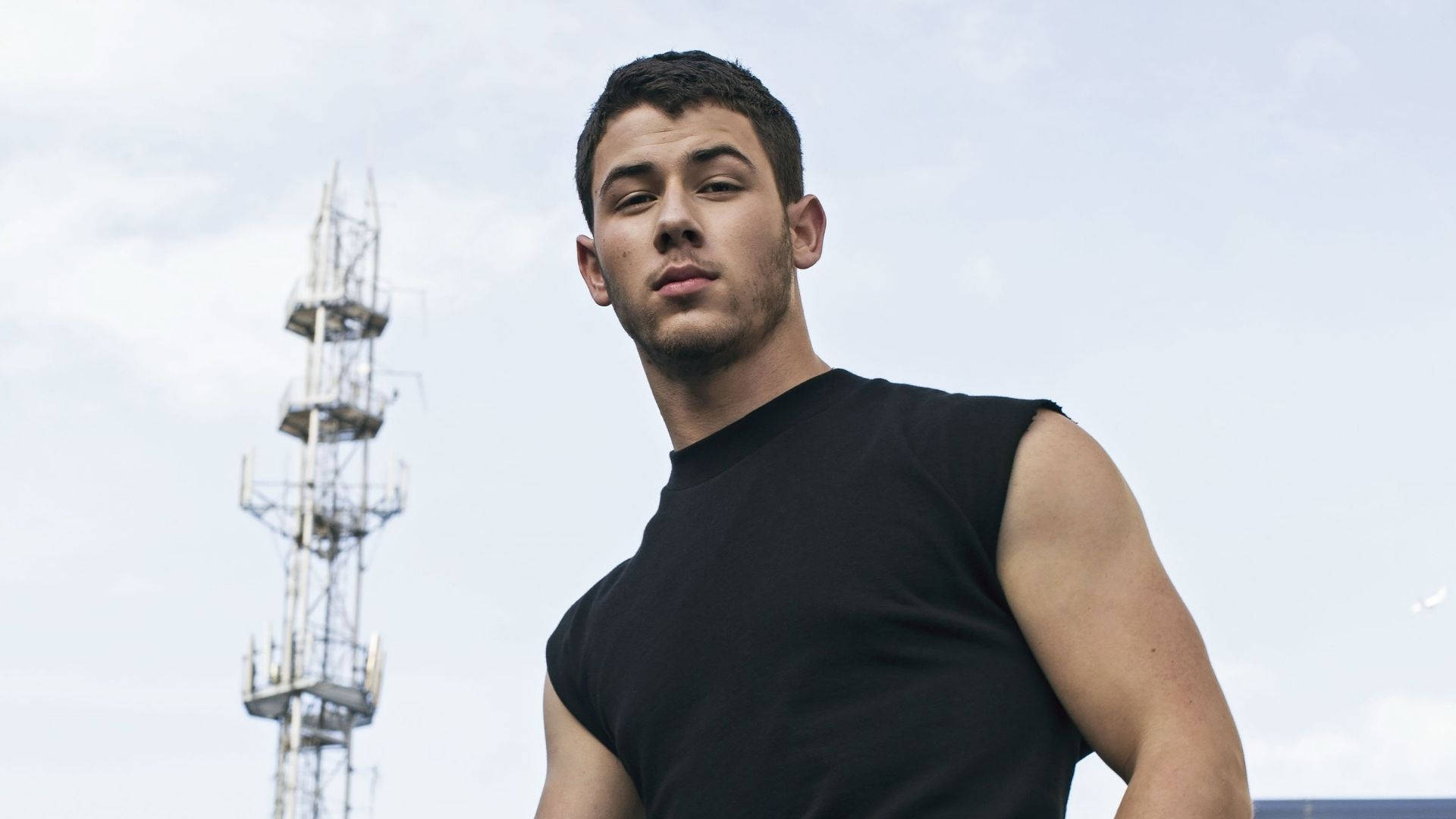 Nick Jonas Commanding Attention In A Sleeveless Tee. Background