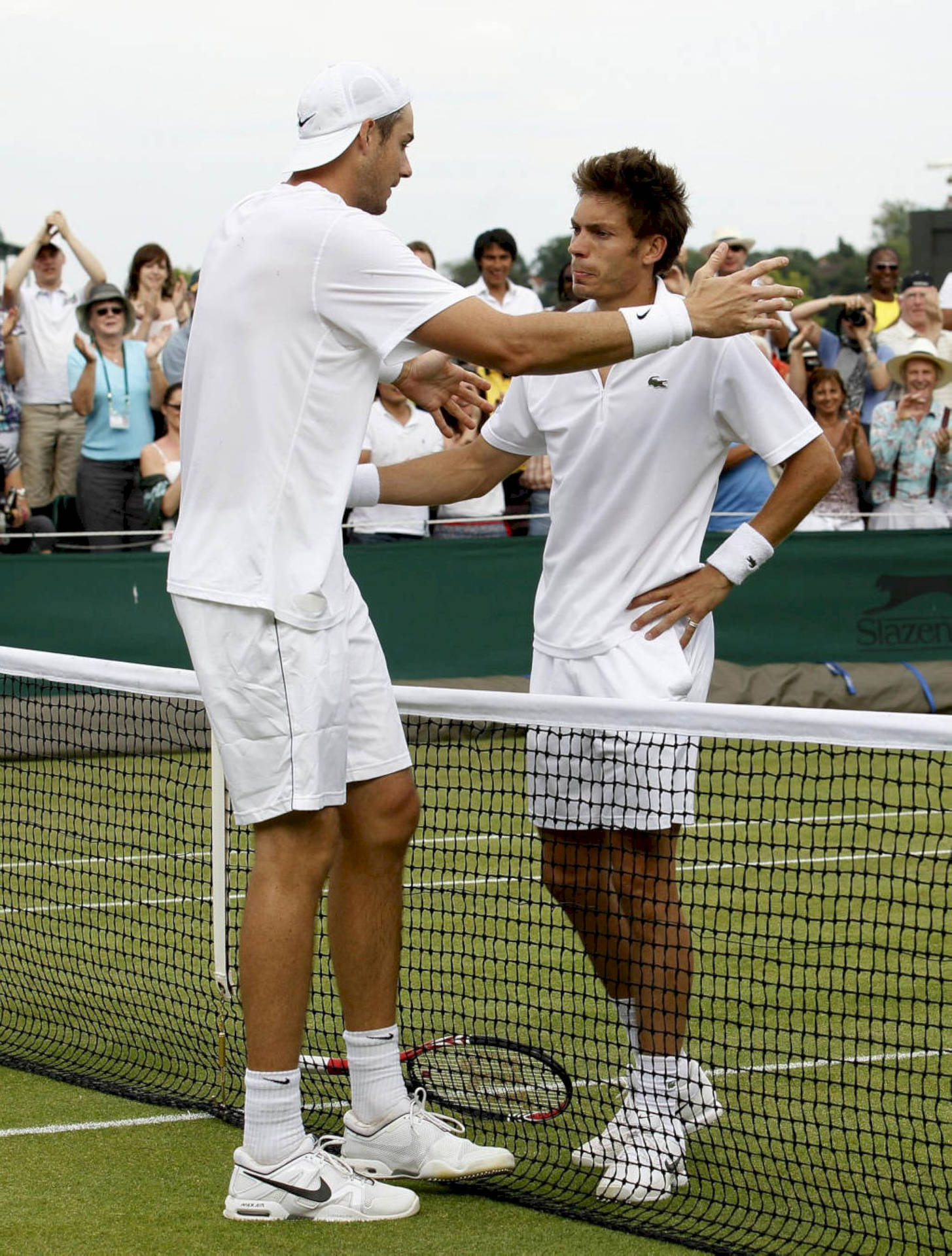 Nicolas Mahut And John Isner Embrace After Feature Match