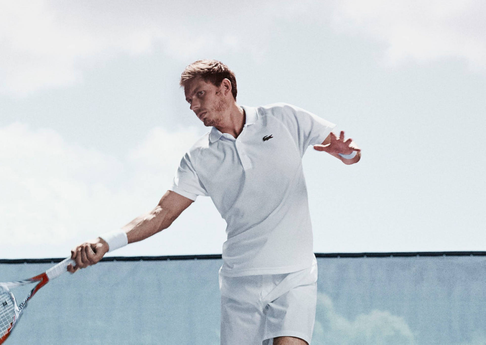 Nicolas Mahut Donned In Lacoste Sportswear, Displaying A Perfect Pose With His Tennis Racquet.