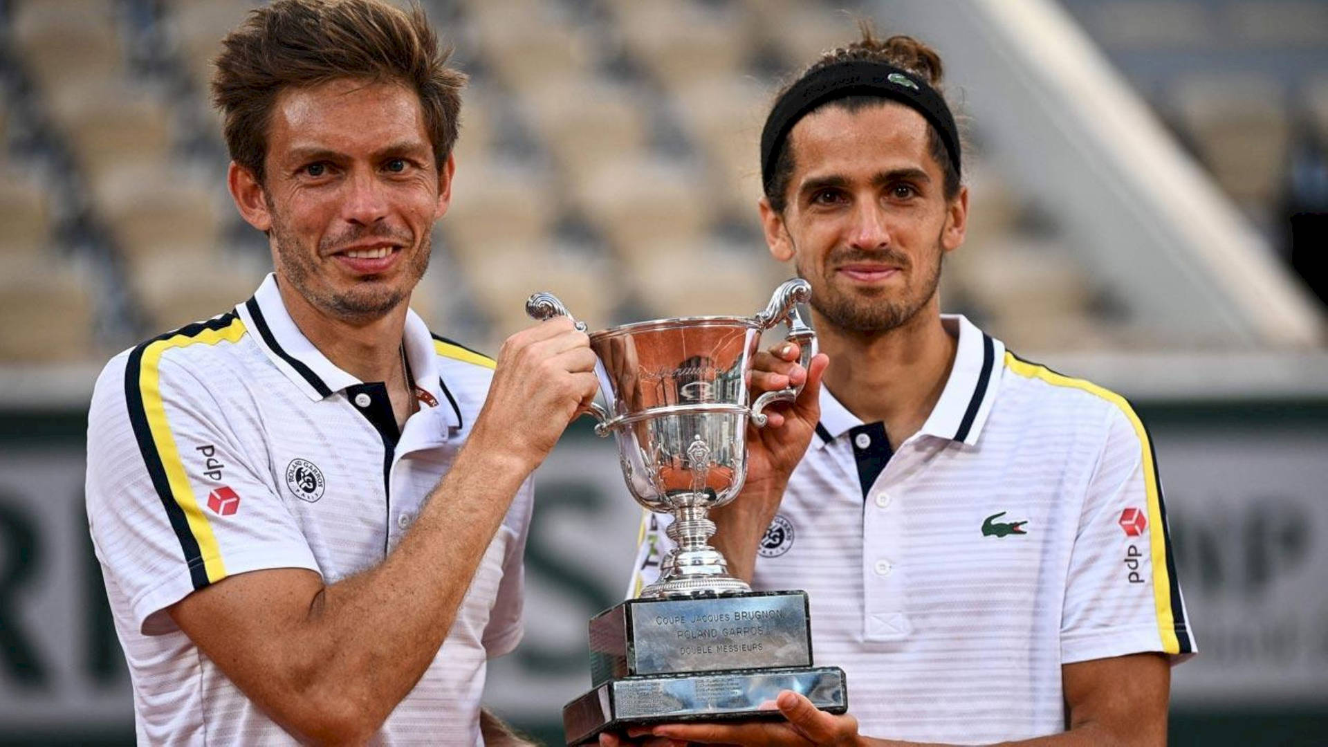 Nicolas Mahut Holding The French Open Trophy Triumphantly Background