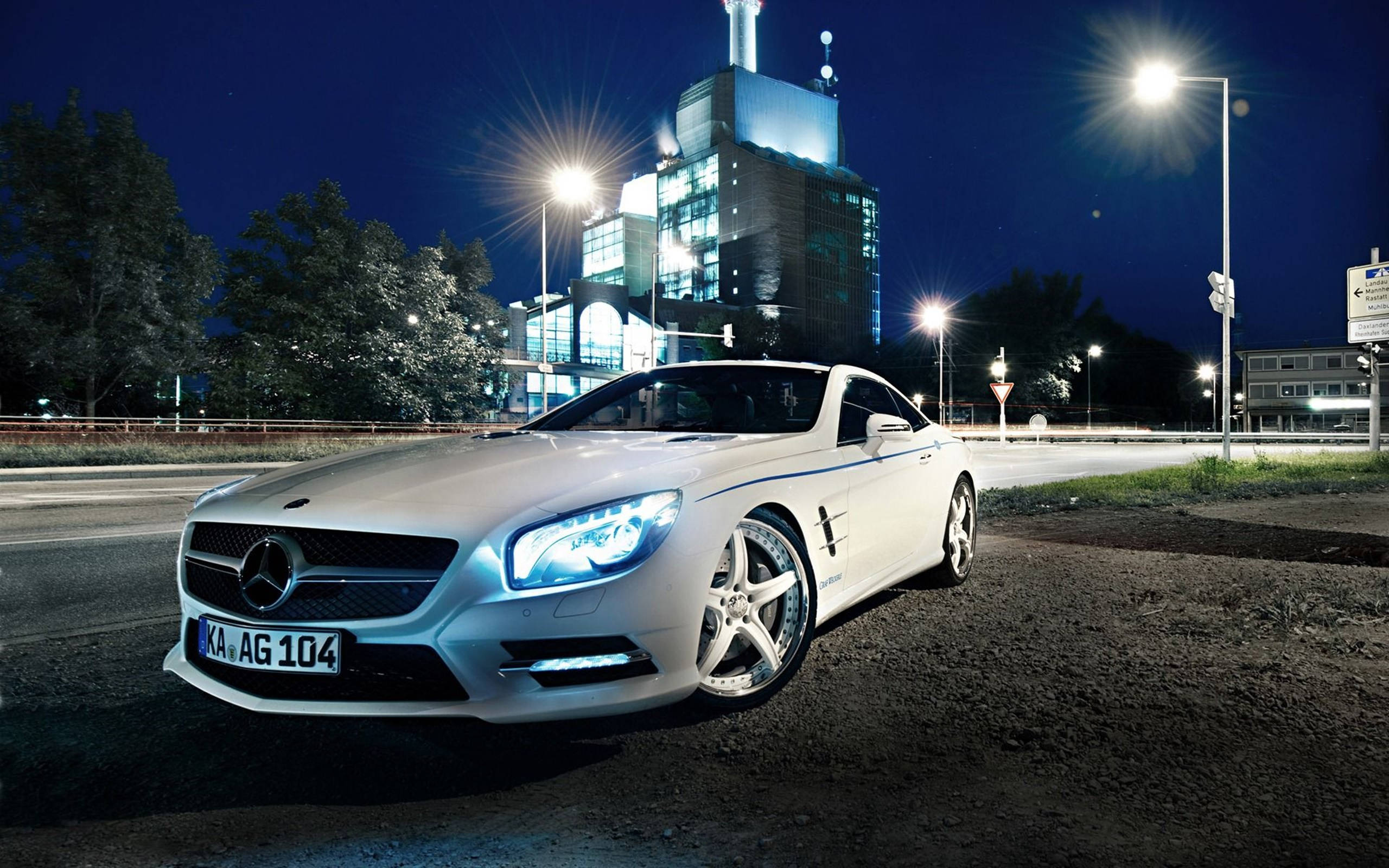 Night Life Luxury: White Mercedes Benz Under City Lights Background