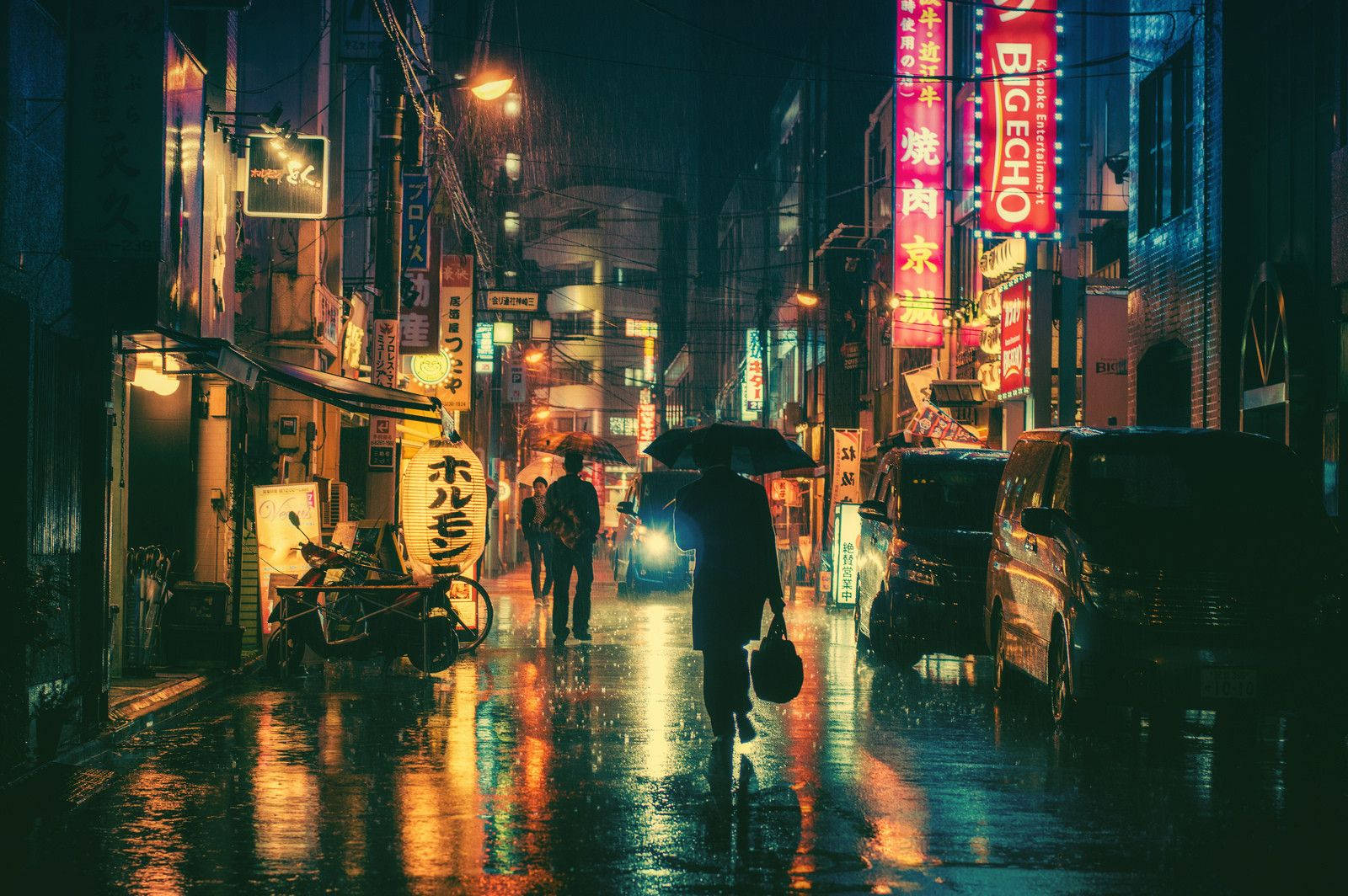 Night Time In Tokyo, Illuminated By Neon Signs On A Rainy Night Background