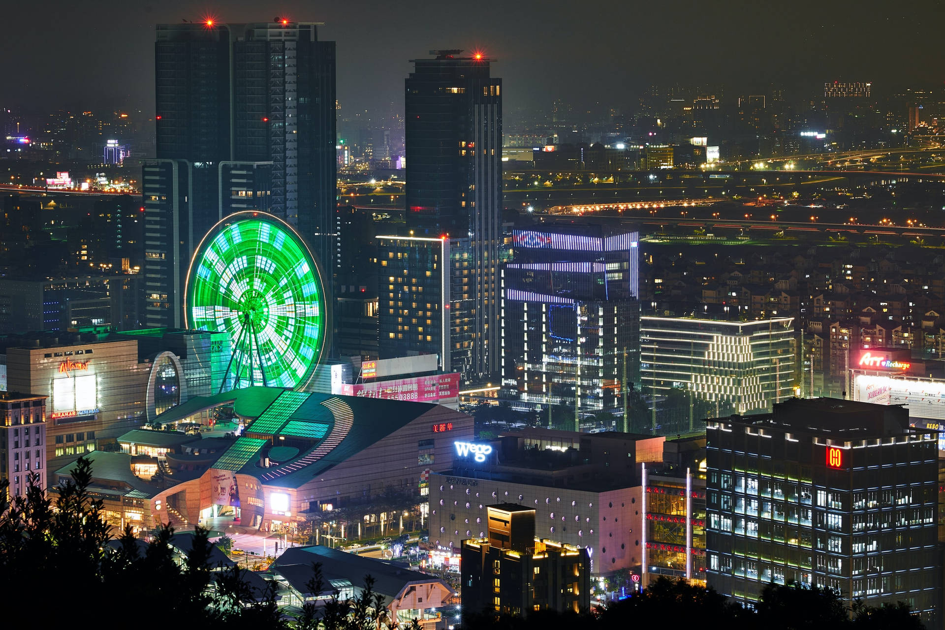 Night View Of The Bustling Cityscape Of Taipei With Miramar Ferris Wheel.