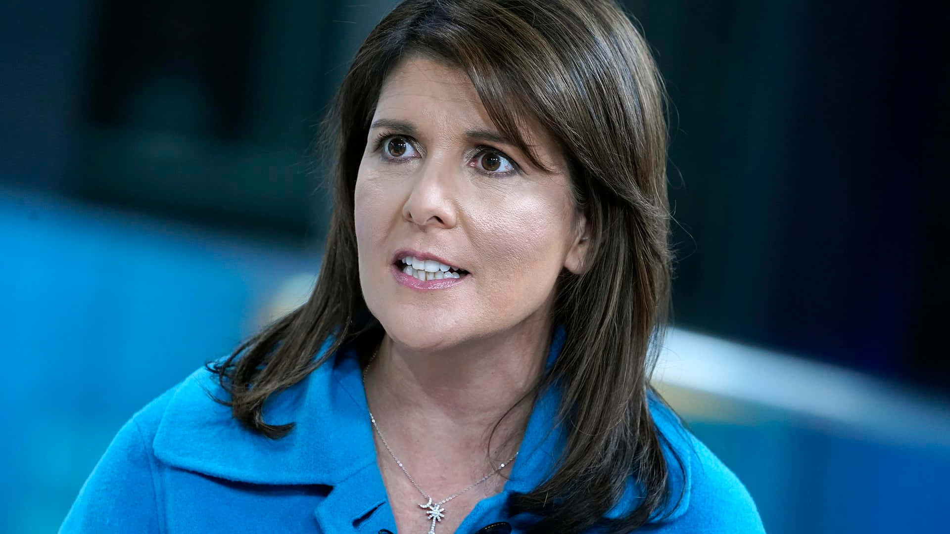 Nikki Haley In A Vibrant Blue Polo Shirt Background