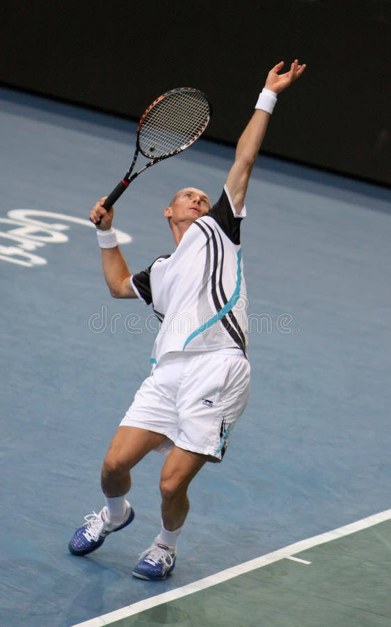 Nikolay Davydenko Delivering A Powerful Jumping Serve In Tennis Match. Background