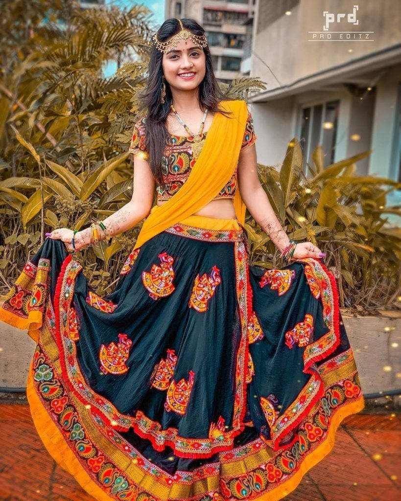Nisha Guragain Adorning A Vibrant Yellow Traditional Gujarati Dress Background