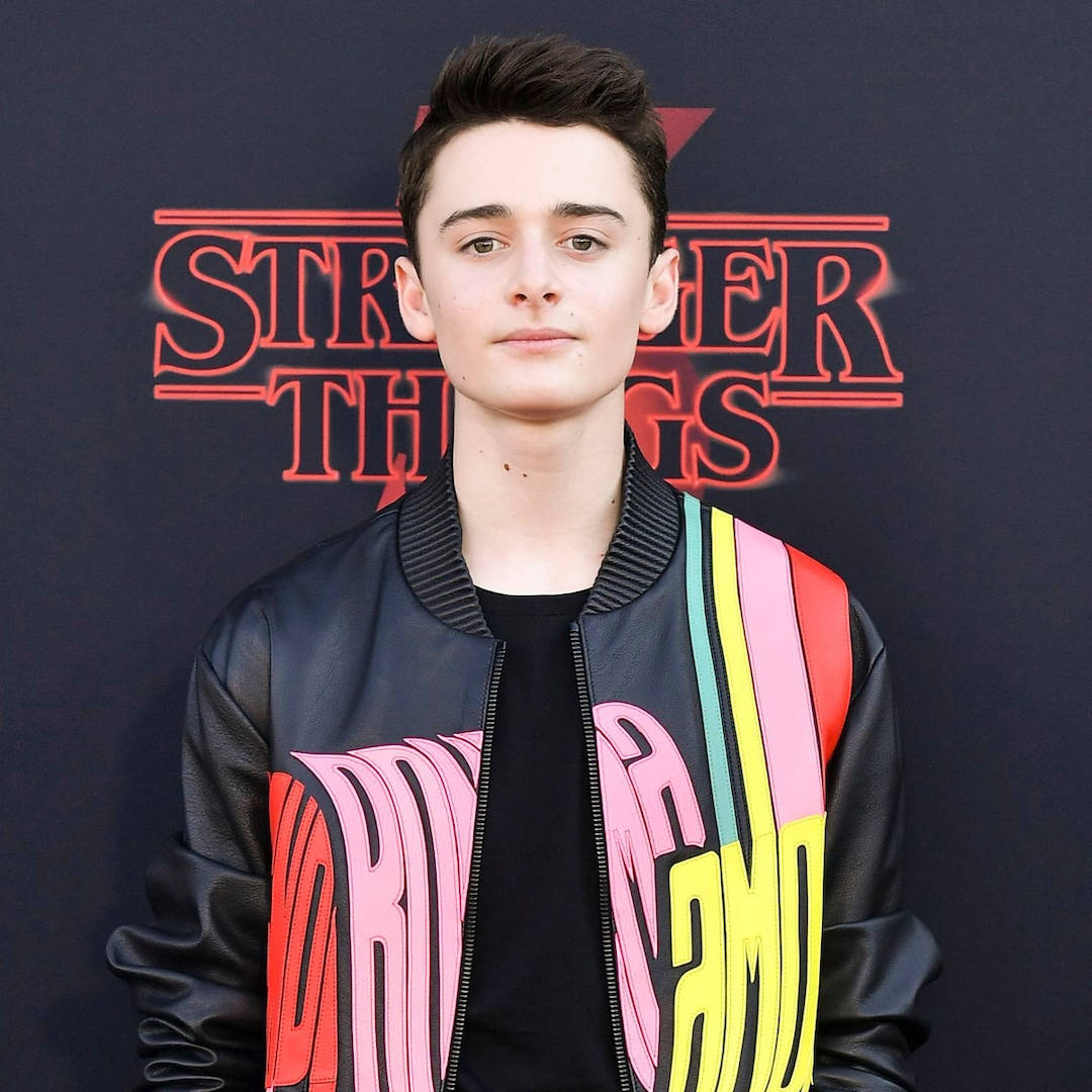 Noah Schnapp Black Jacket With Colorful Details Background