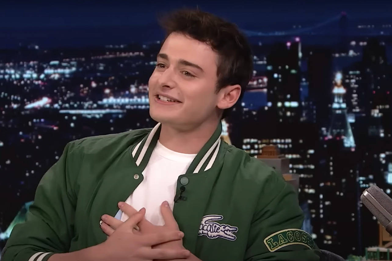 Noah Schnapp Stylishly Dressed In Green Lacoste Bomber Jacket Background