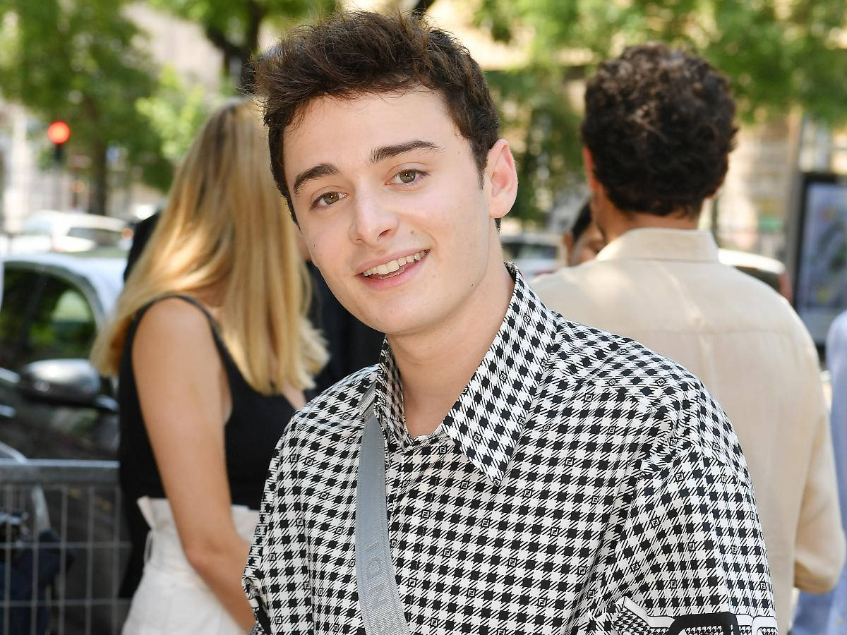 Noah Schnapp With Chekered Polo Outside Background