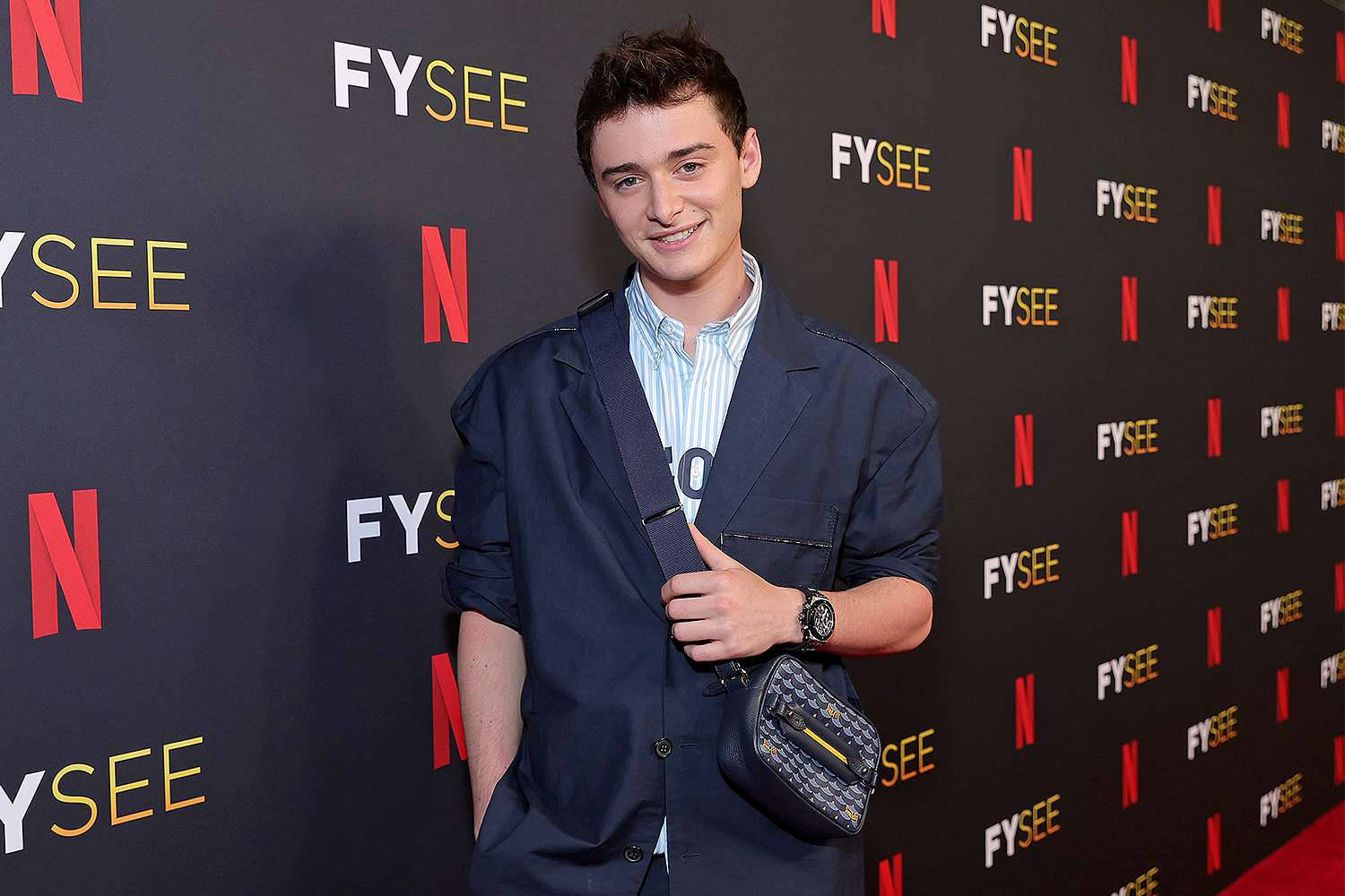 Noah Schnapp With Suit And Sling Bag Background