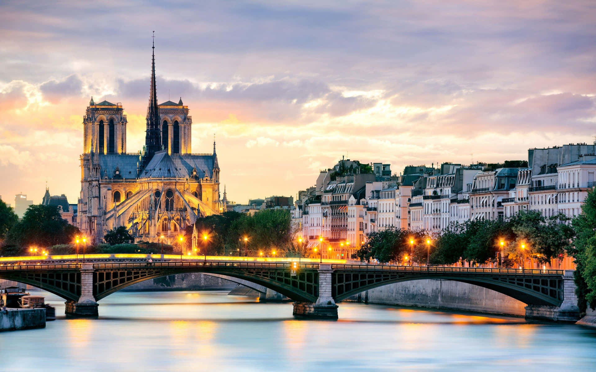 Notre Dame Cathedral With Bridge Lit With Orange Lights Background