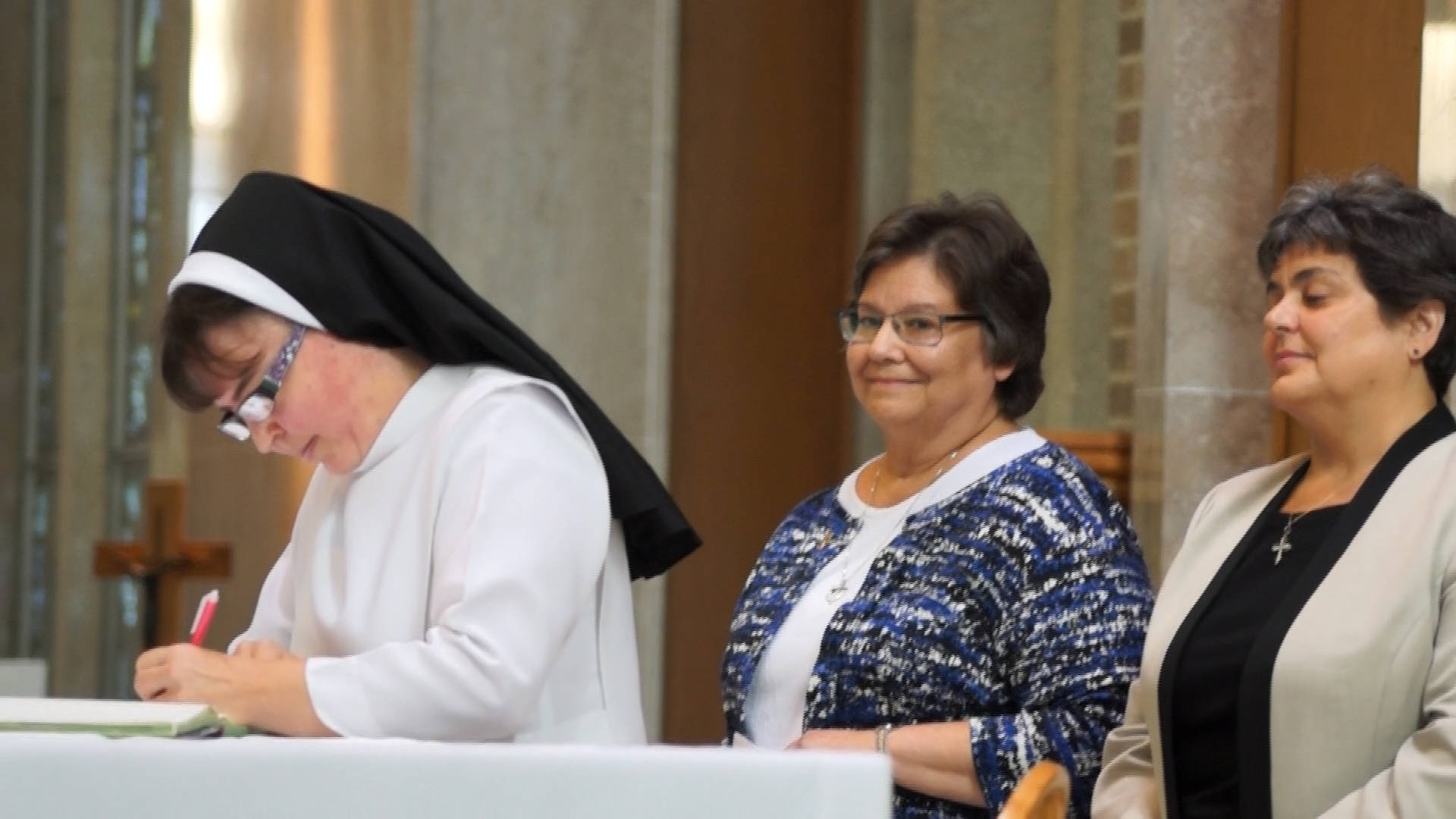 Nun Signing With Two Women Background