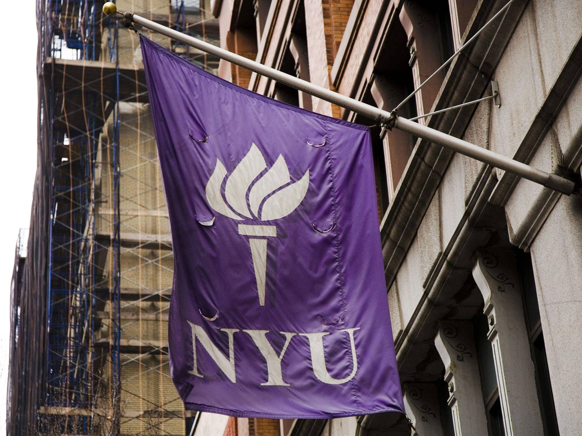 Nyu Hanging Sign On A Pole Background