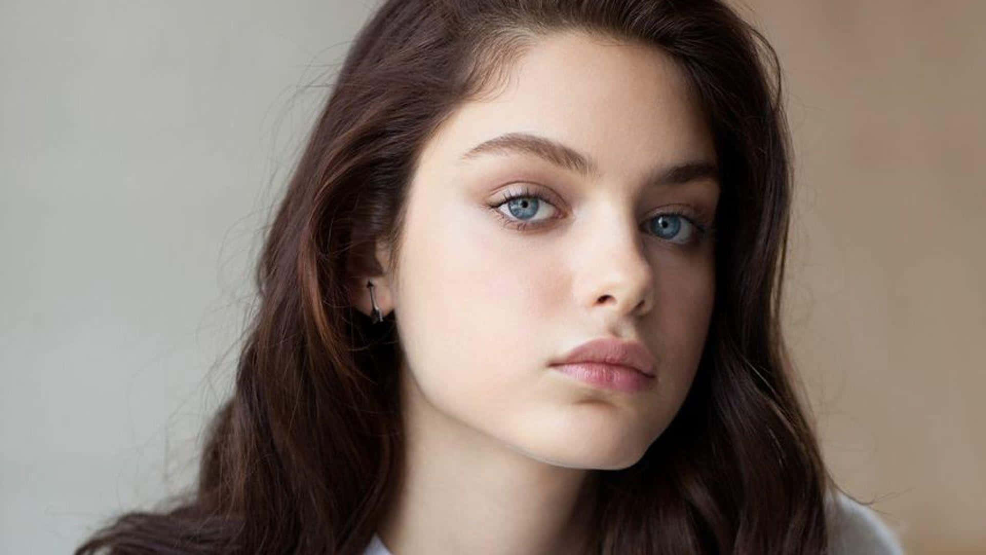 Odeya Rush Stunningly Smiles While Maintaining Eye Contact With The Camera Background