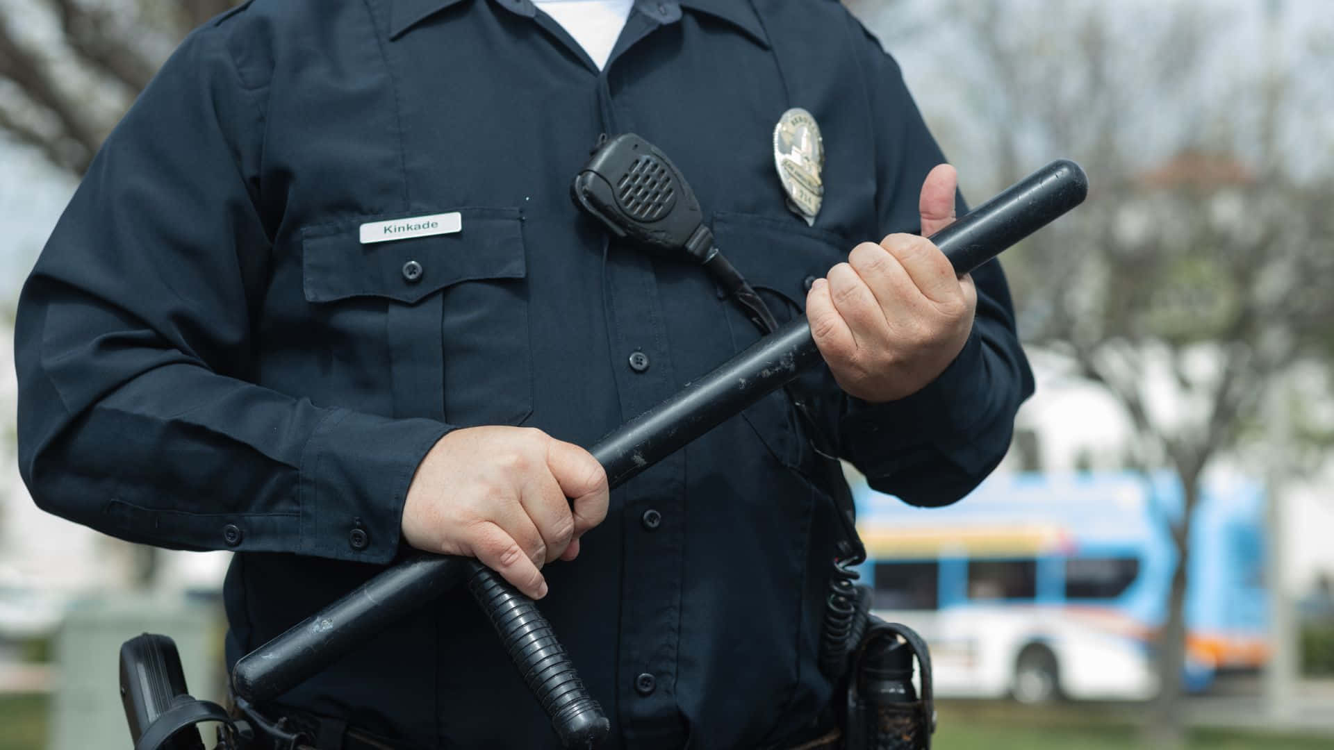 Officer Keeping The Community Safe By Patrolling The Streets Background