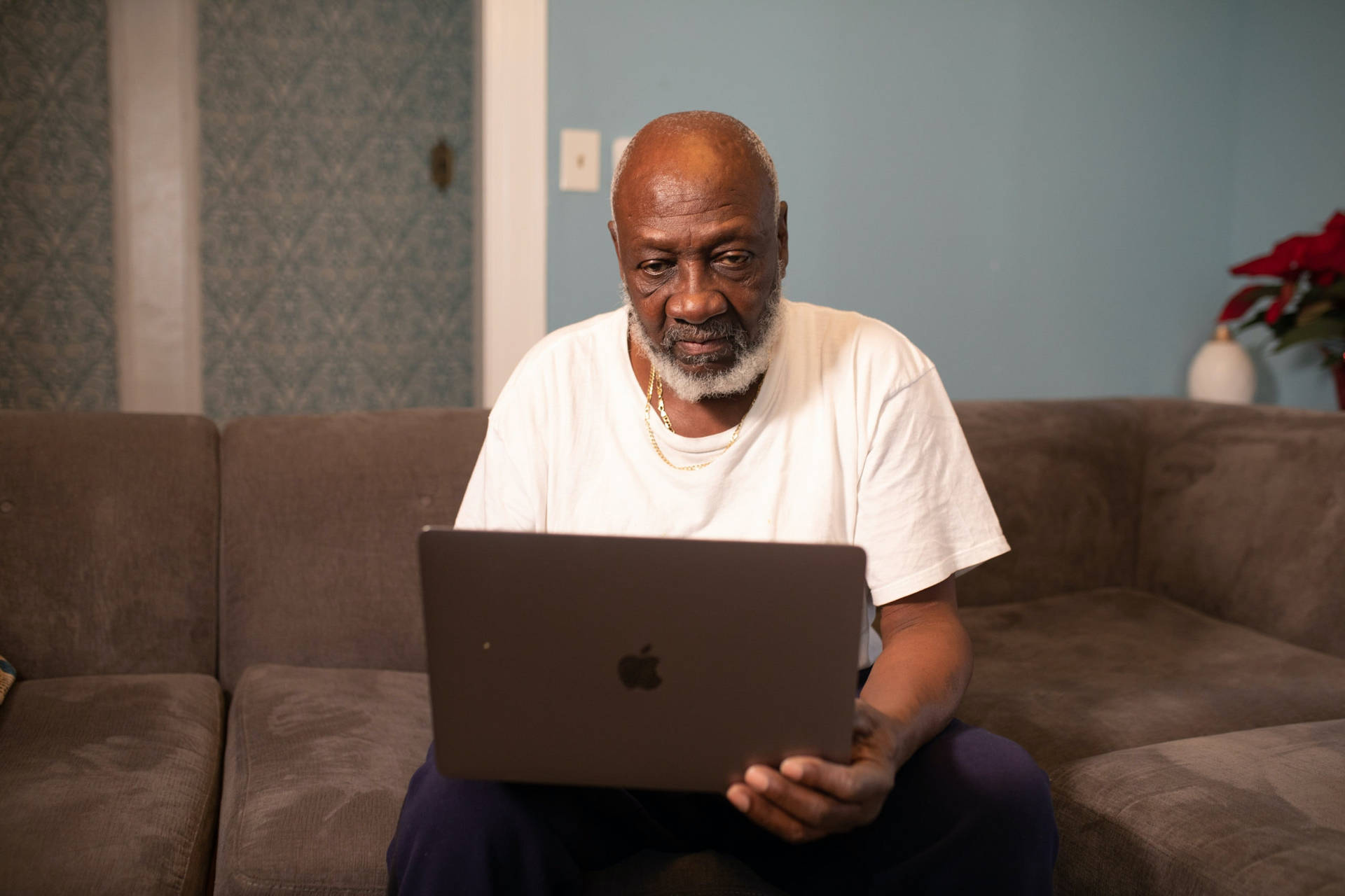 Old Black Man Using Laptop On Couch