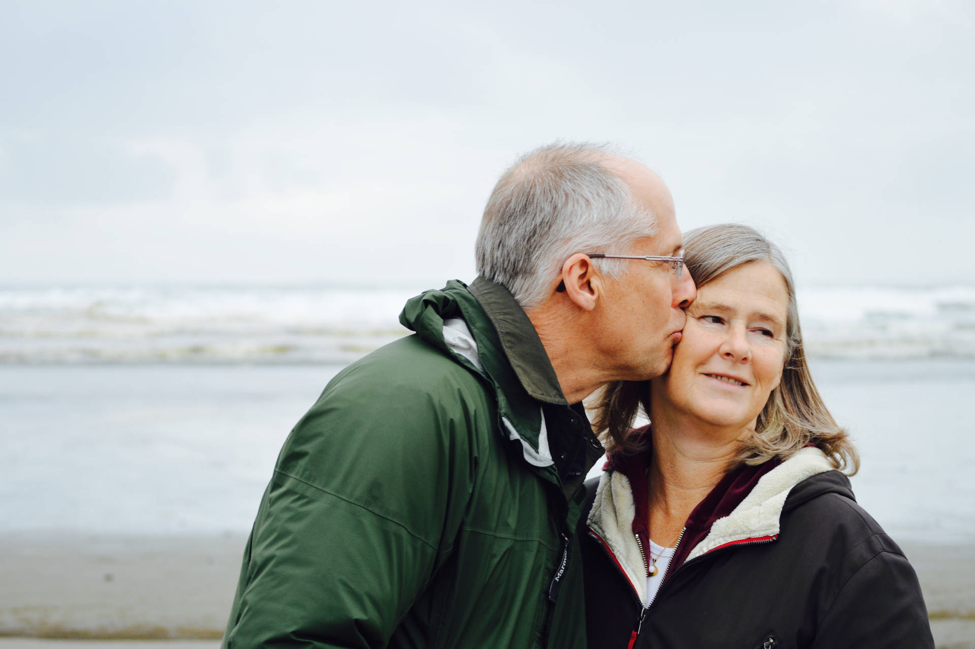Old Couple Kiss By The Beach Background