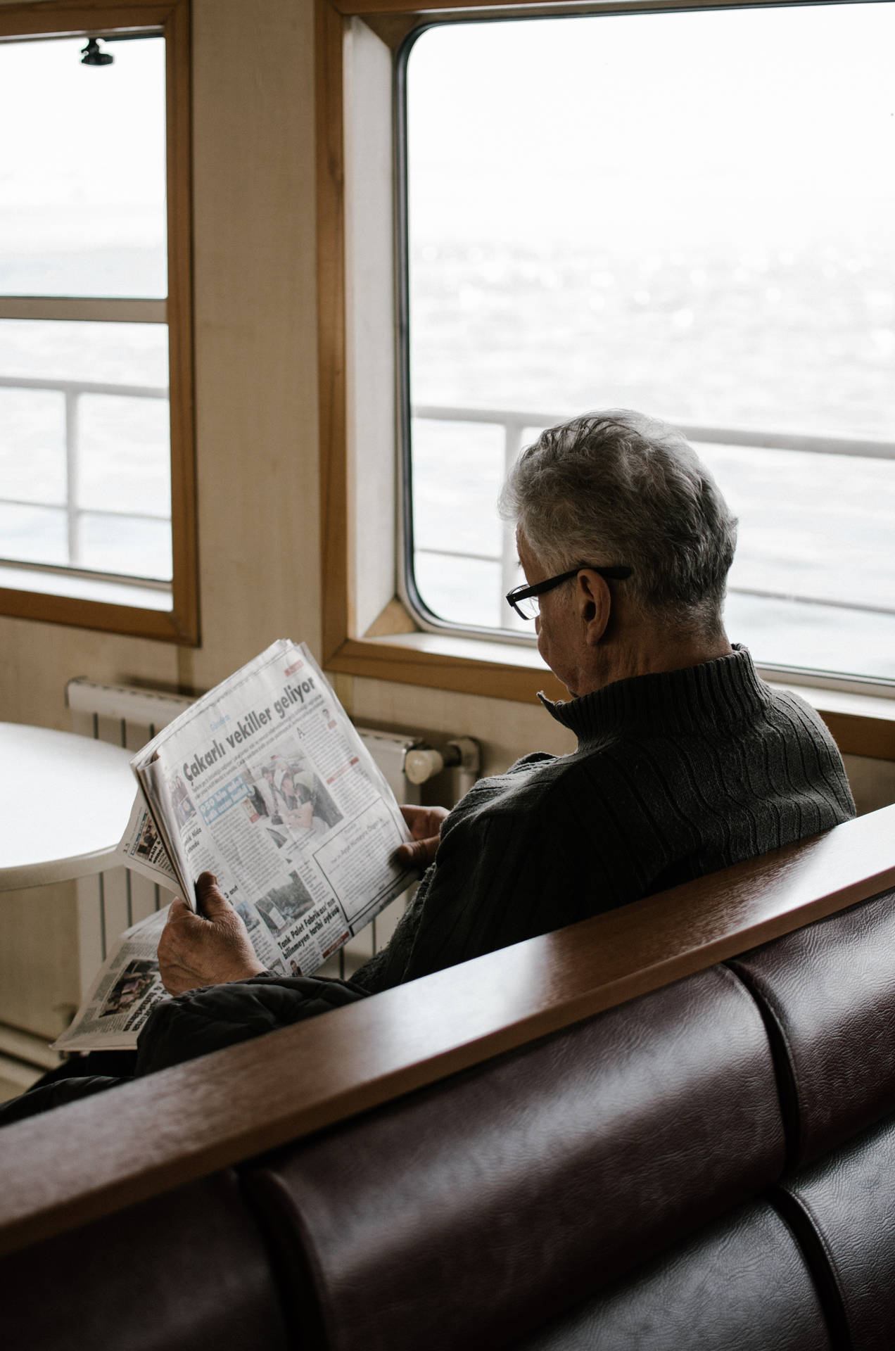 Old Man Reading Newspaper In Ship