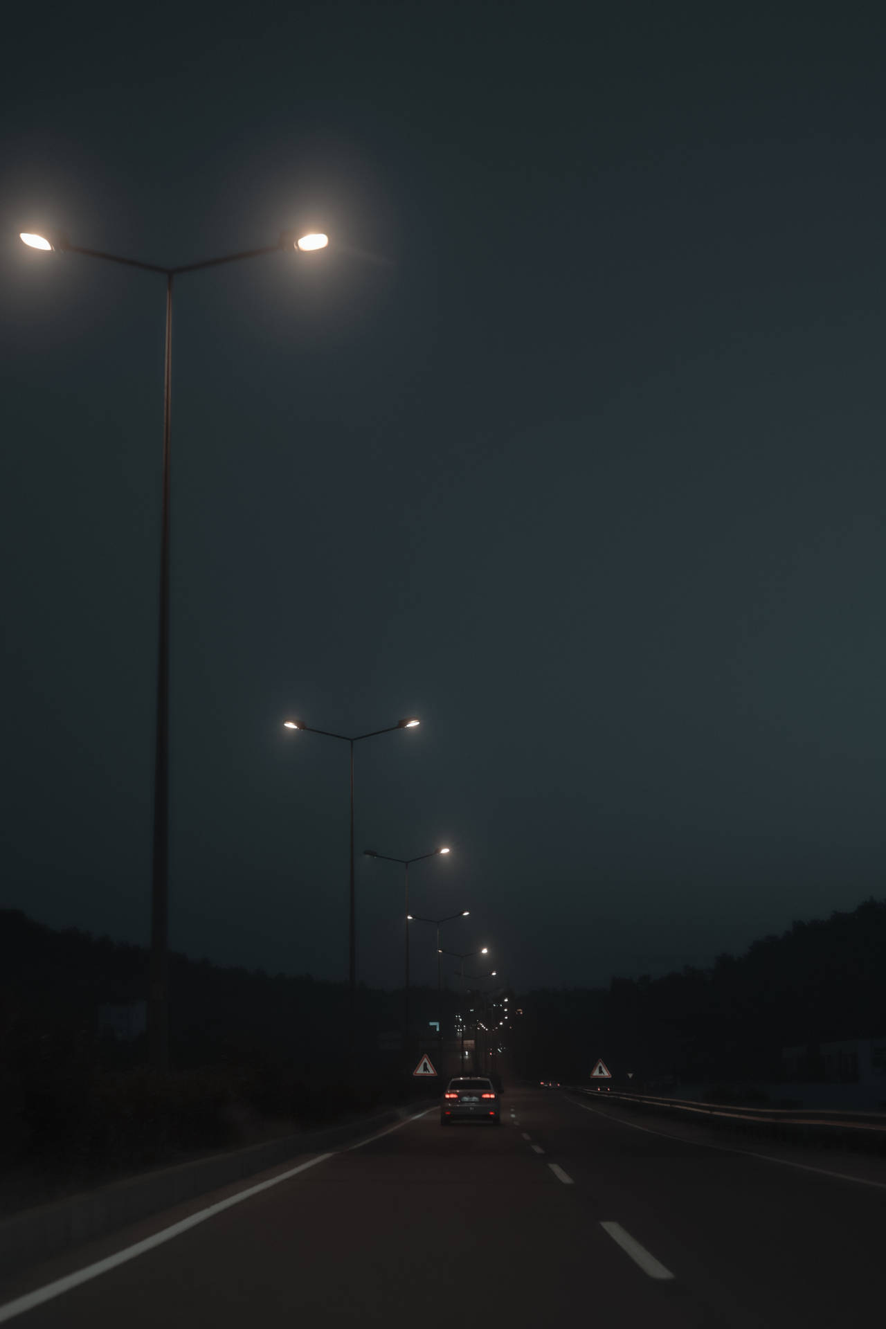 Old Street Lights Beside The Road On A Dim Evening Background