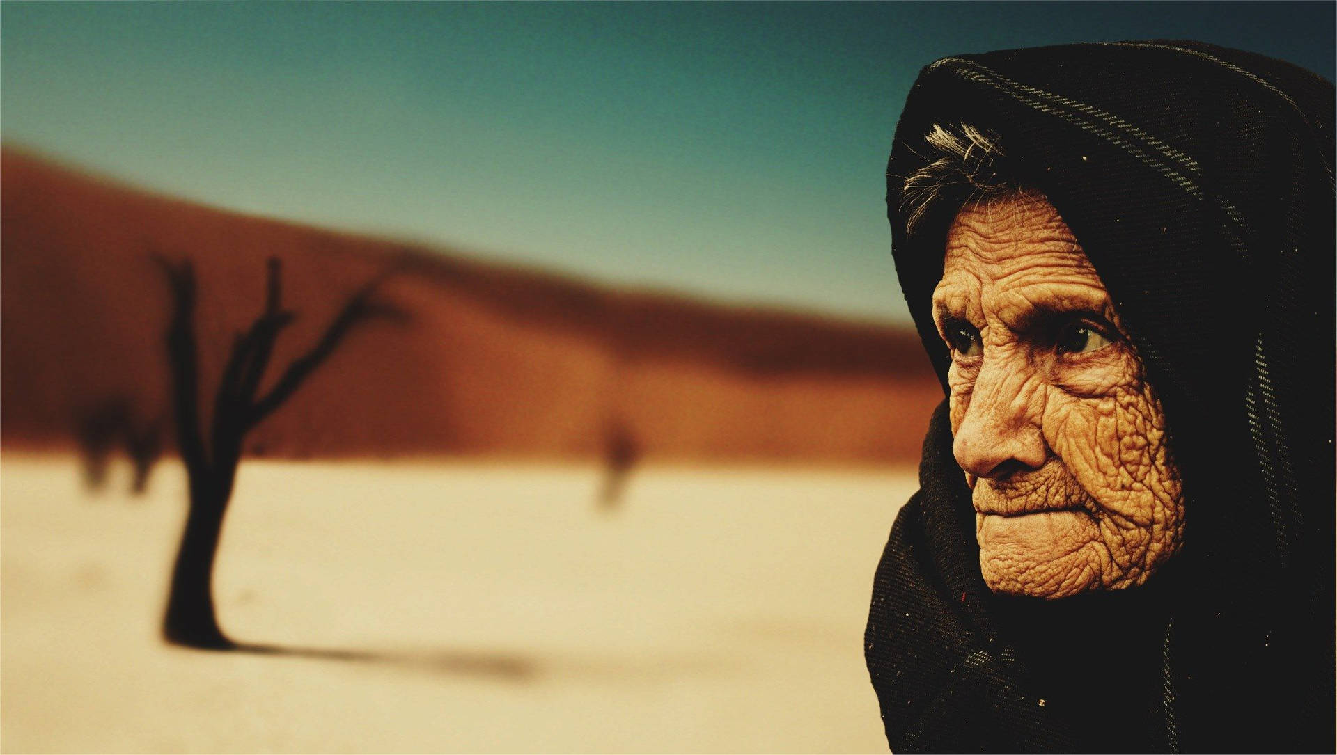 Old Woman In The Desert Background