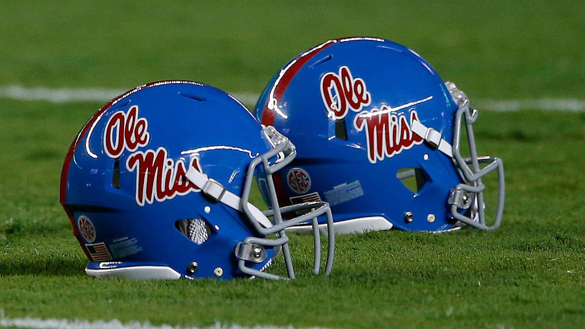 Ole Miss Football Helmets On Field Background