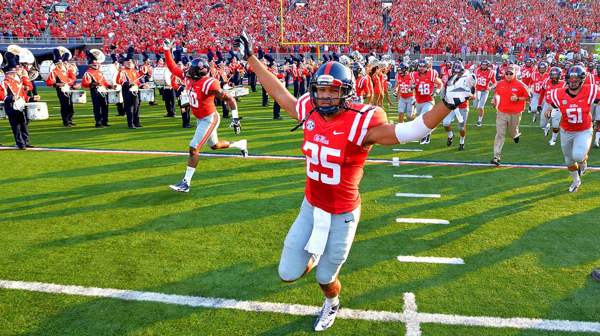 Ole Miss Player Running On Field Background